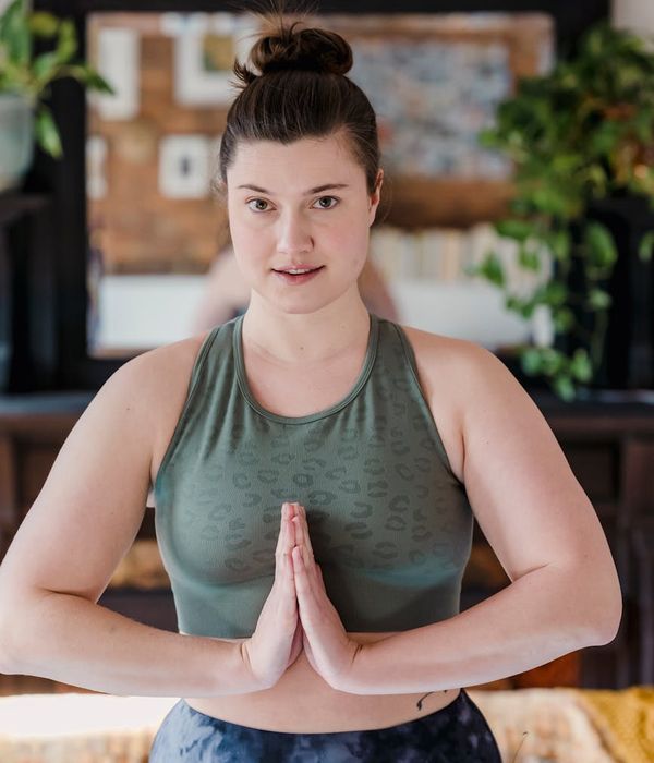 Woman performing a calm yoga pose in a dark, serene environment.